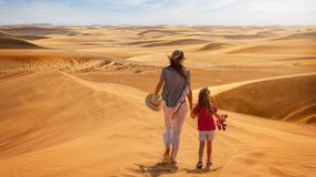 A mother and daughter in the sand dunes when spending a week in Dubai.