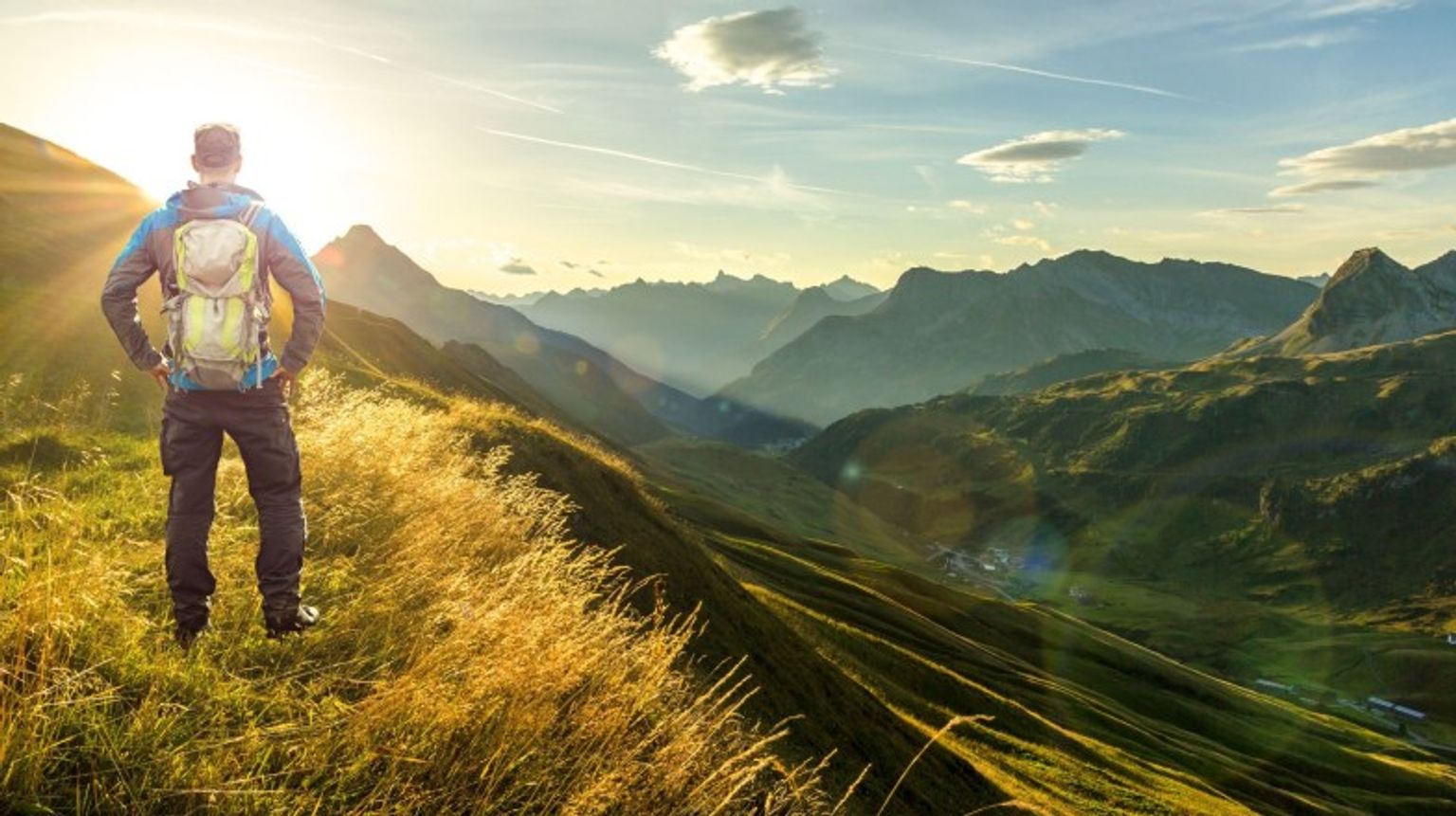 Austria in October offers ideal conditions for outdoor enthusiasts, with crisp autumn weather perfect for hiking amidst stunning landscapes, exploring charming villa A hiker in the Alps of Austria in October during dusk admiring the beauty.