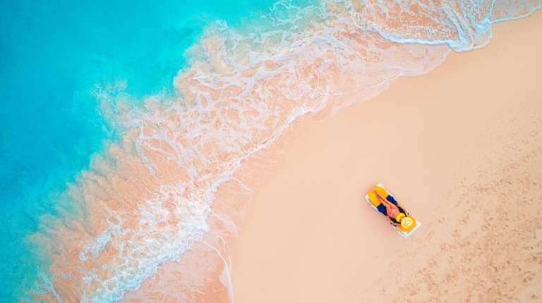 Aerial view of a woman lying on the beach and sunbathing in Cuba in June.