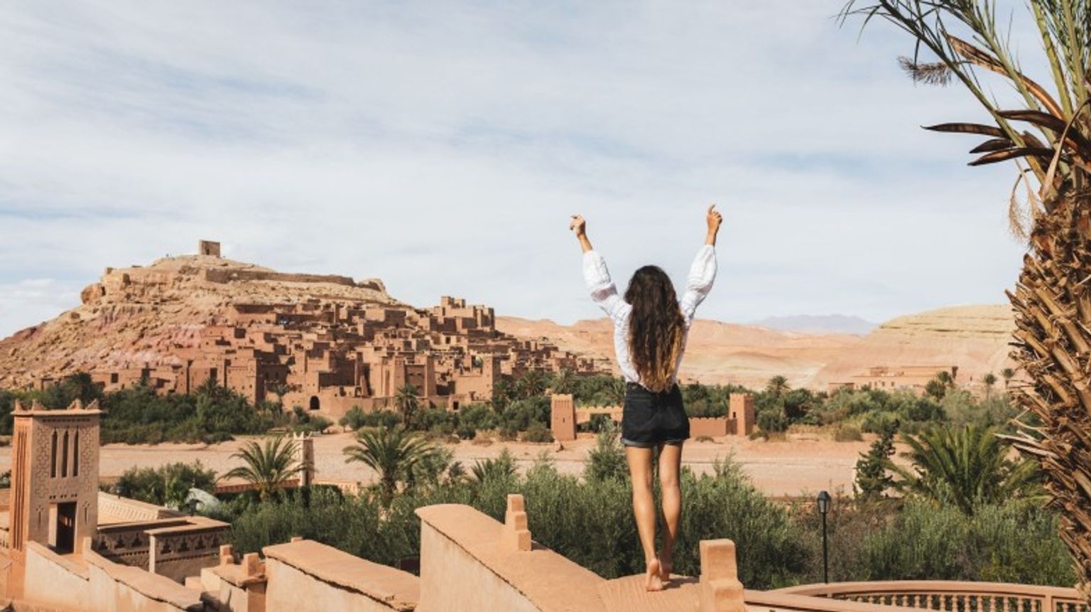 Step into a world of history and cinematic charm at Ksar Ait-Ben-Haddou in Ouarzazate—an iconic gem and one of the top places to visit in Morocco! A happy girl in Ouarzazate, one of the top places to visit in Morocco.