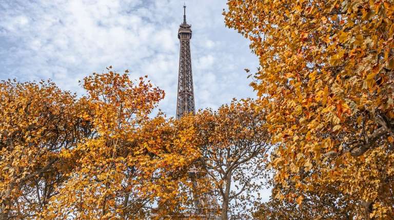 The Eiffel Tower adorned with fall colors in France in October.