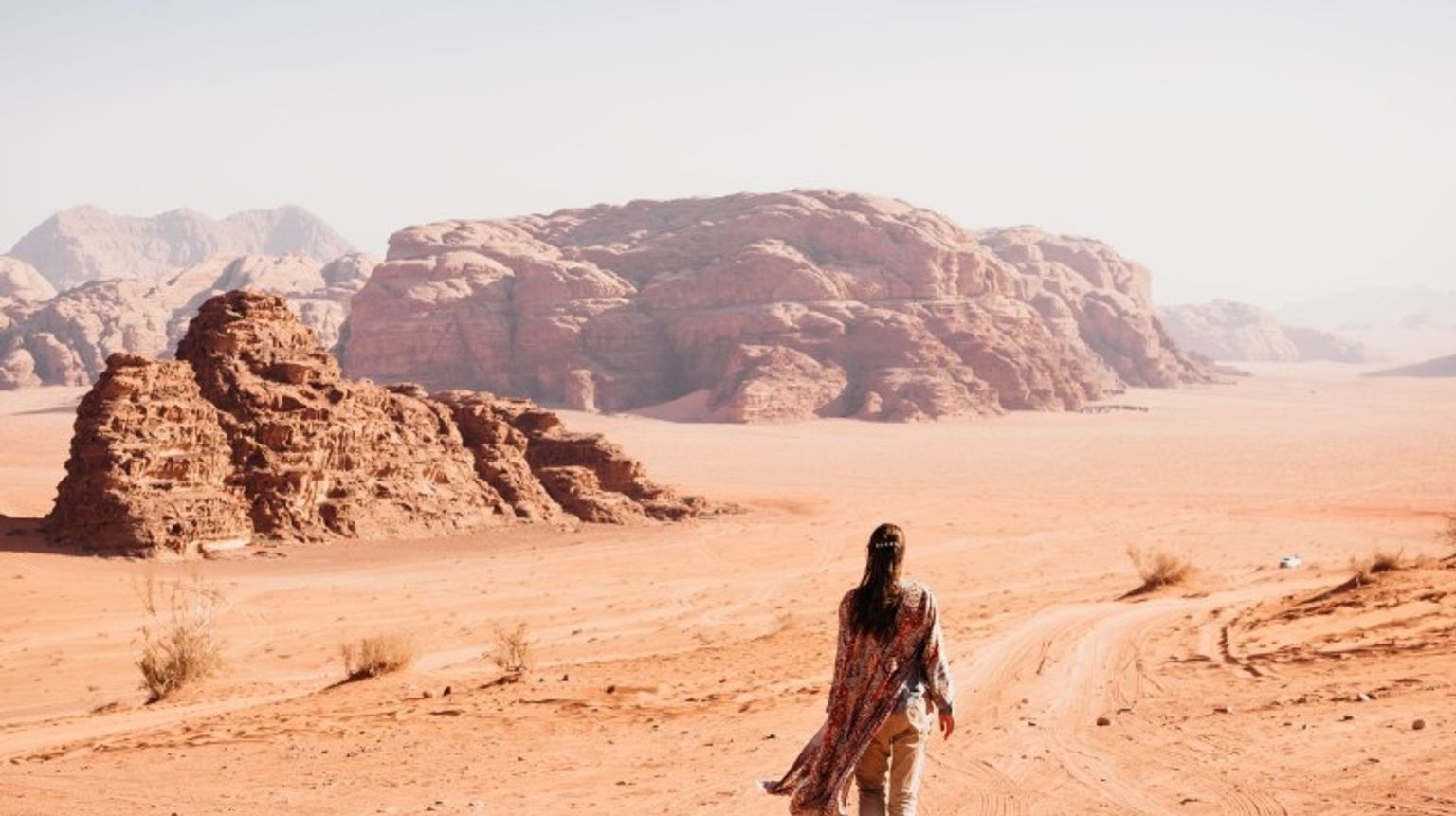 Discover the beauty of Wadi Rum in Jordan in September, with cooler weather ideal for exploring its stunning desert landscapes. A woman walking in Wadi Rum in Jordan in September.