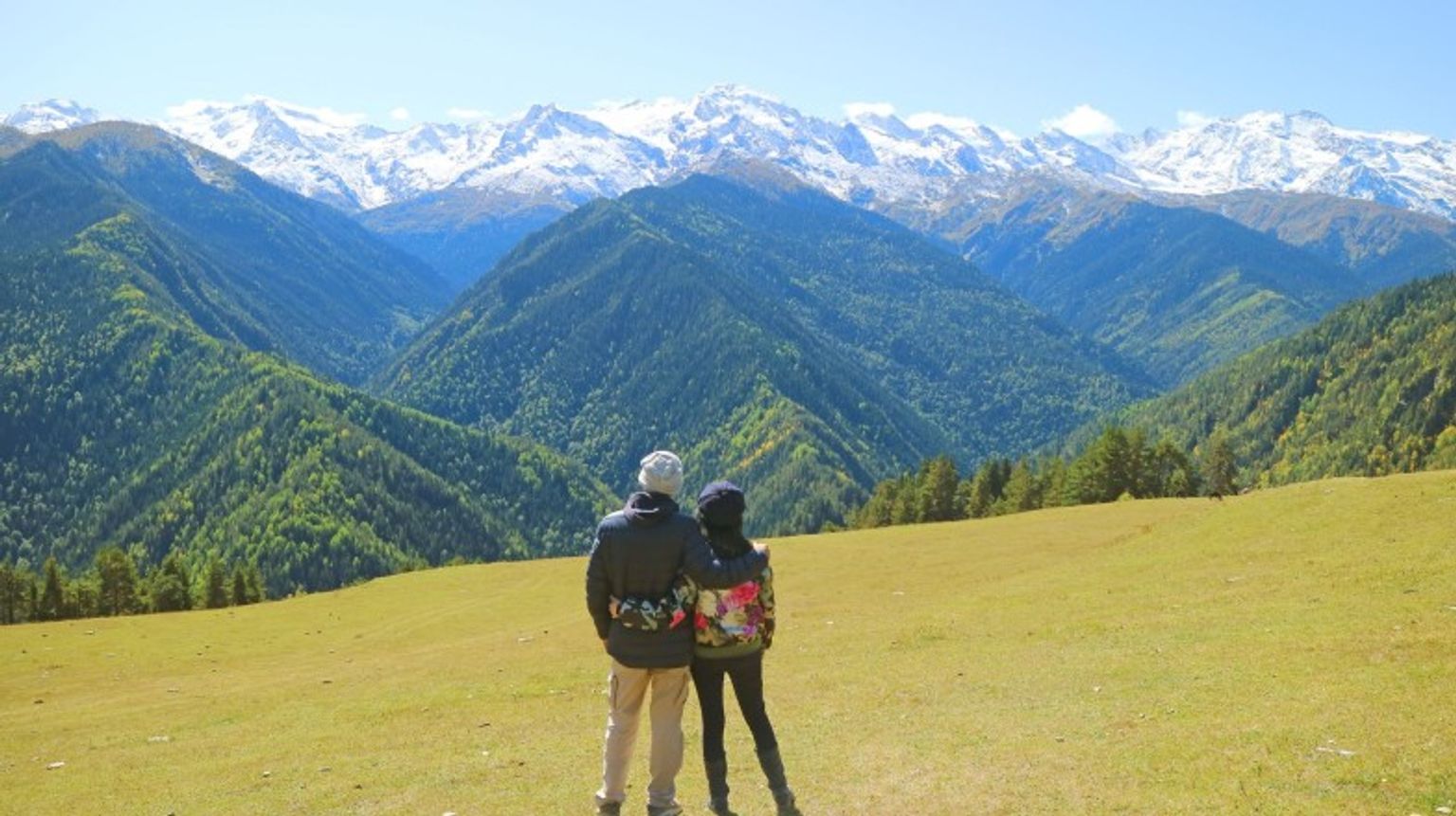 Hike the stunning Caucasus Mountains during your one week in Georgia for breathtaking peaks and unforgettable trails. A couple hiker admiring the view of the Caucasus Mountain during their one week in Georgia.