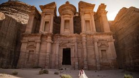 A woman in white dress standing at Ad Deir in Petra during her one week in Jordan.