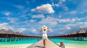 A girl walking on the wooden plank on an island during her one week in the Maldives.