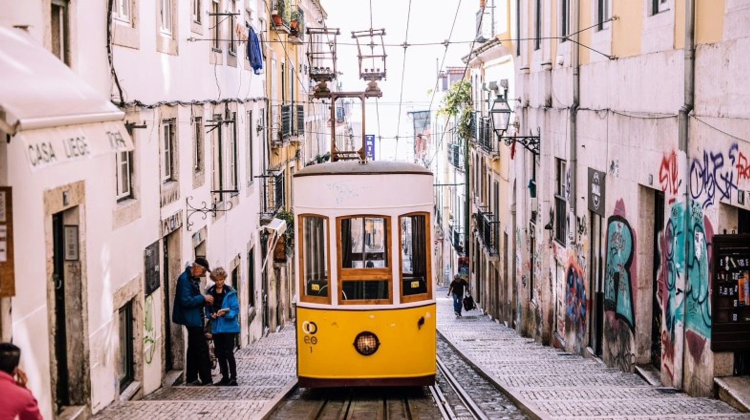 Lisbon is best explored on foot. So, wear comfortable walking shoes. The yellow tram in the alley of Lisbon in Portugal during an 8 day trip