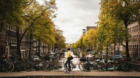 A girl walks past a bridge over a canal in Amsterdam, Netherlands