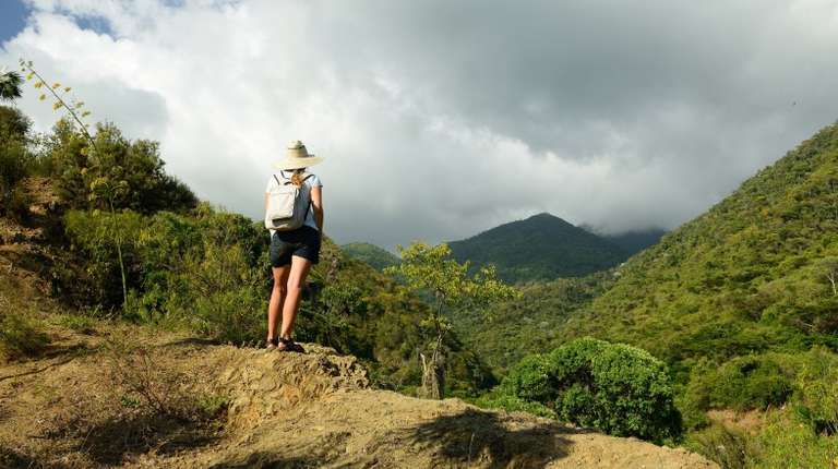 Woman looking at a mountain on her hike through the Sierra Maestra during winter in Cuba.