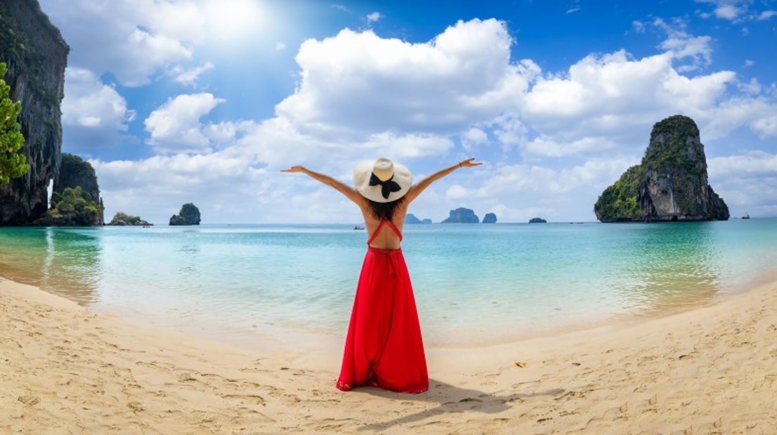 Experience paradise on Krabi's stunning beaches, a must-visit destination when exploring Thailand in December. A girl with open arms on Krabi beach in Thailand in December.