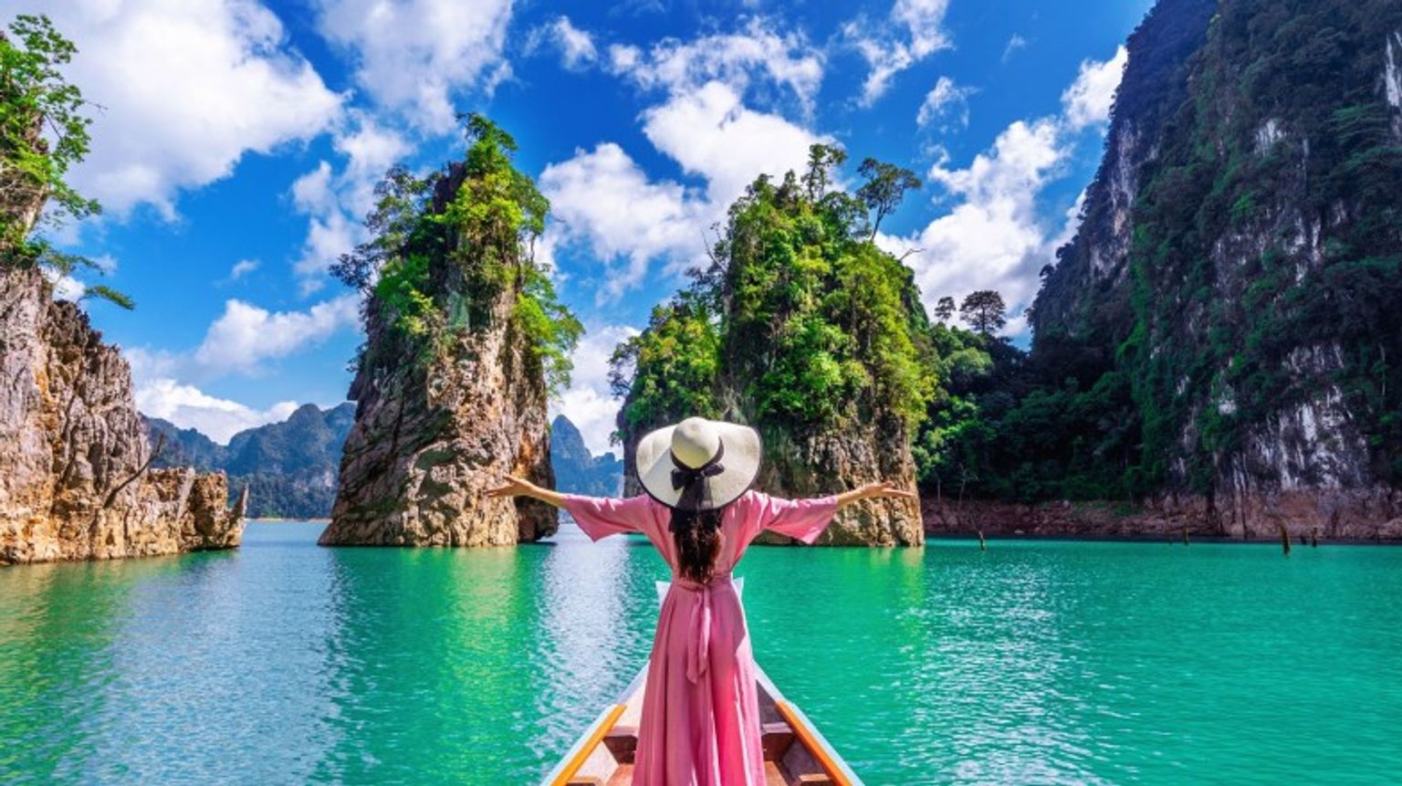 A woman with open arms on a bot in Khao National Park in Thailand in January.