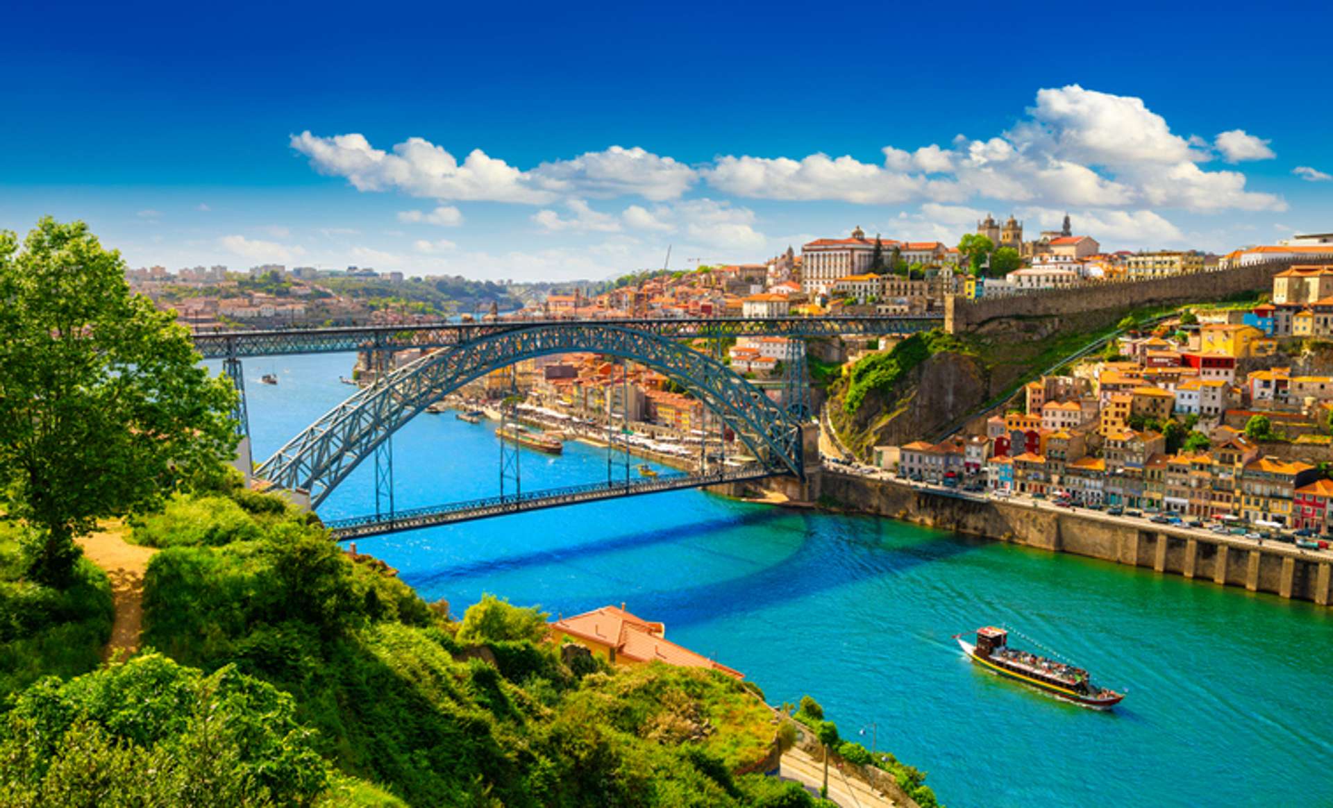 View of Douro river flowing through Porto with a bridge and the city in sight