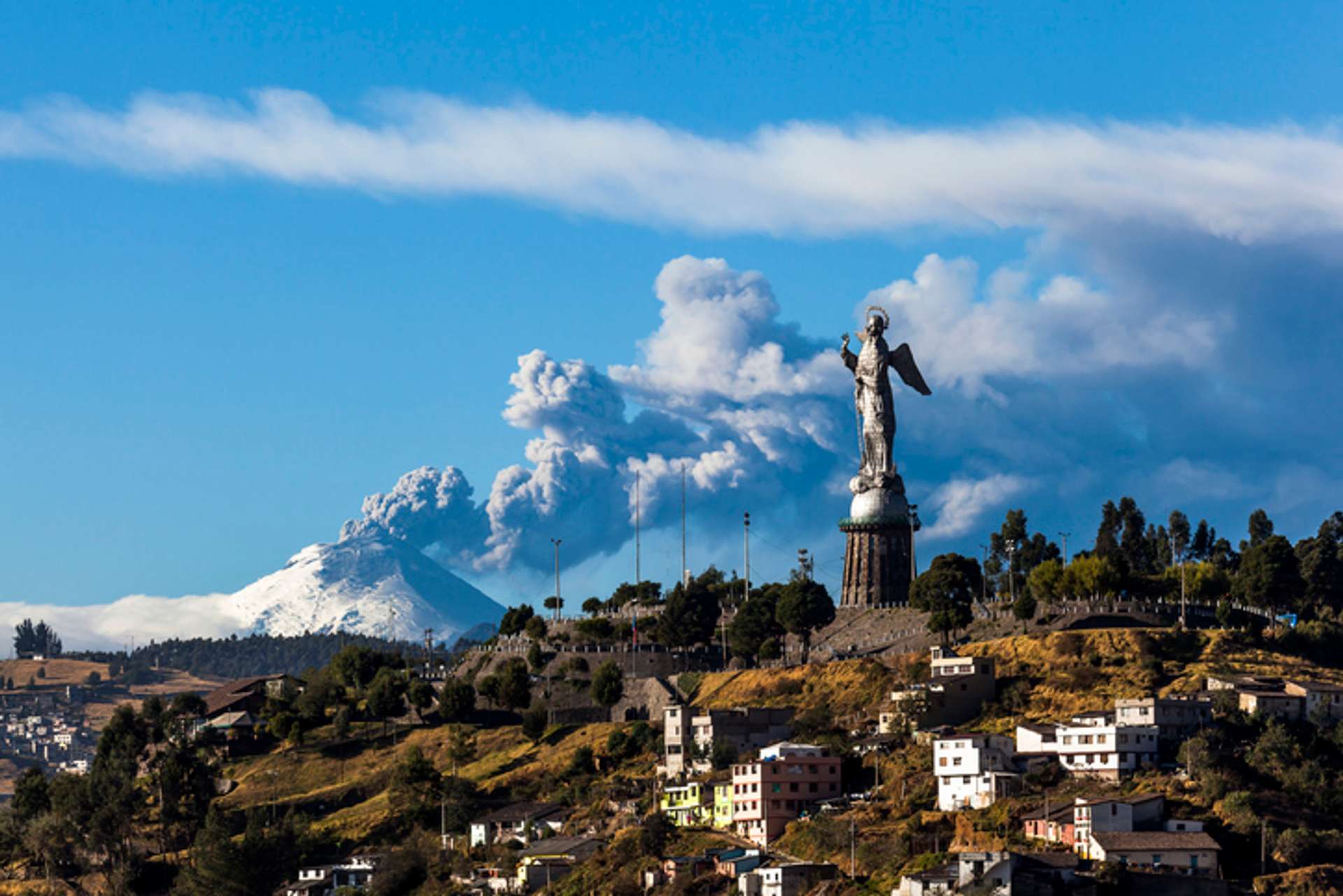 View of a recently erupted Cotapaxi Volcano and Panecillo's Madona seen from Quito