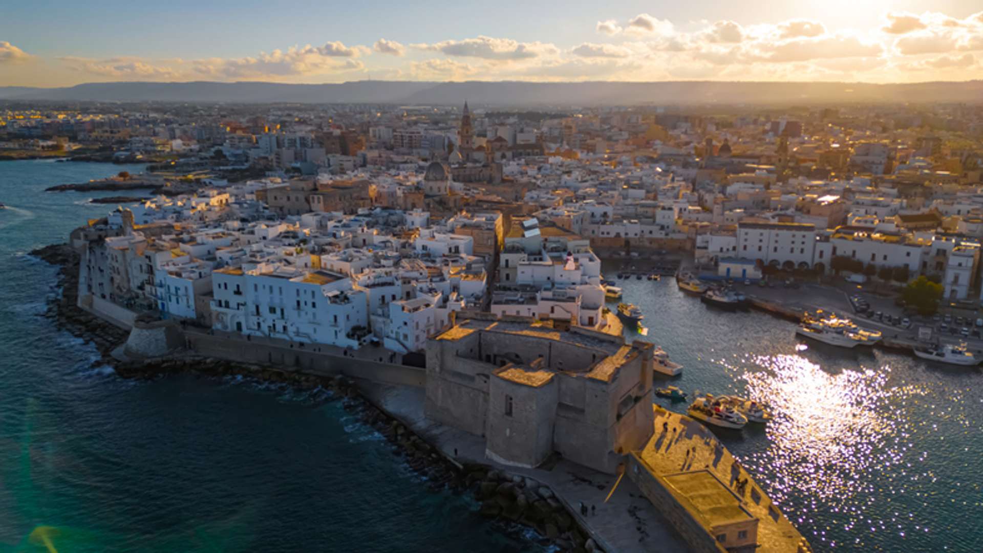 Aerial view of white-washed city of Puglia with the sea lining its edges