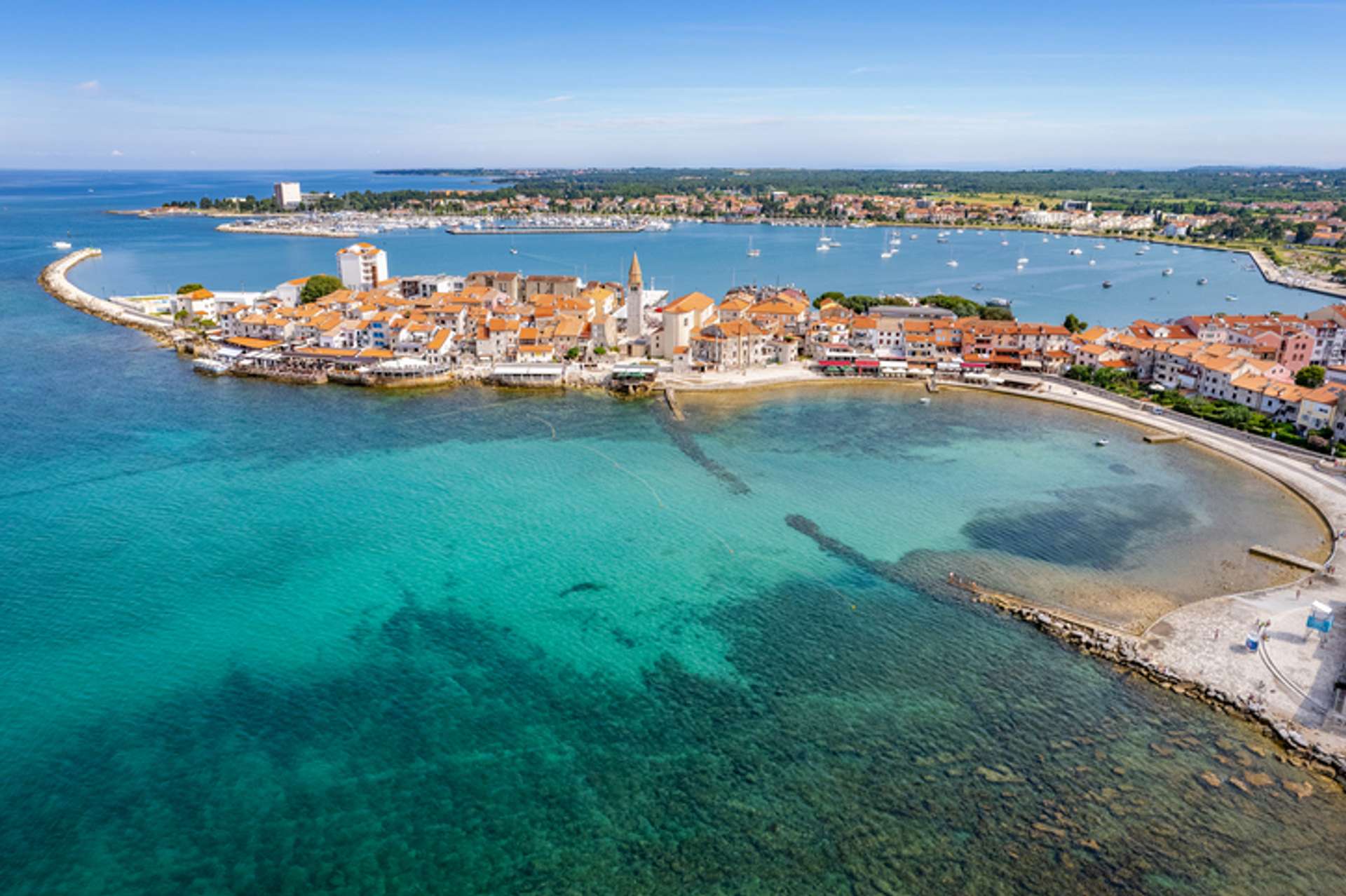 An island village with white houses surrounded by turquoise water