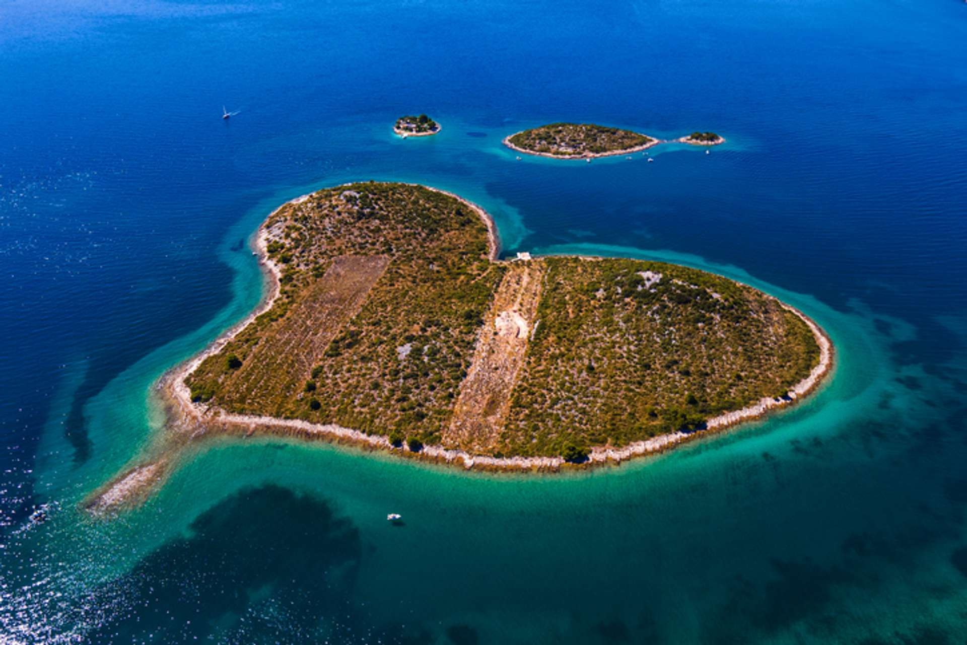 Aerial view of heart-shaped island surrounded by blue sea