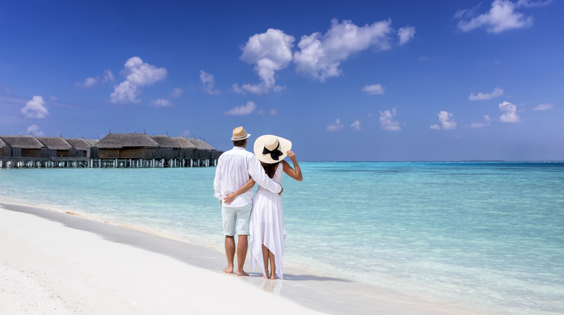 A couple enjoying their time at a tropical beach, one of the best places to visit in the Maldives.