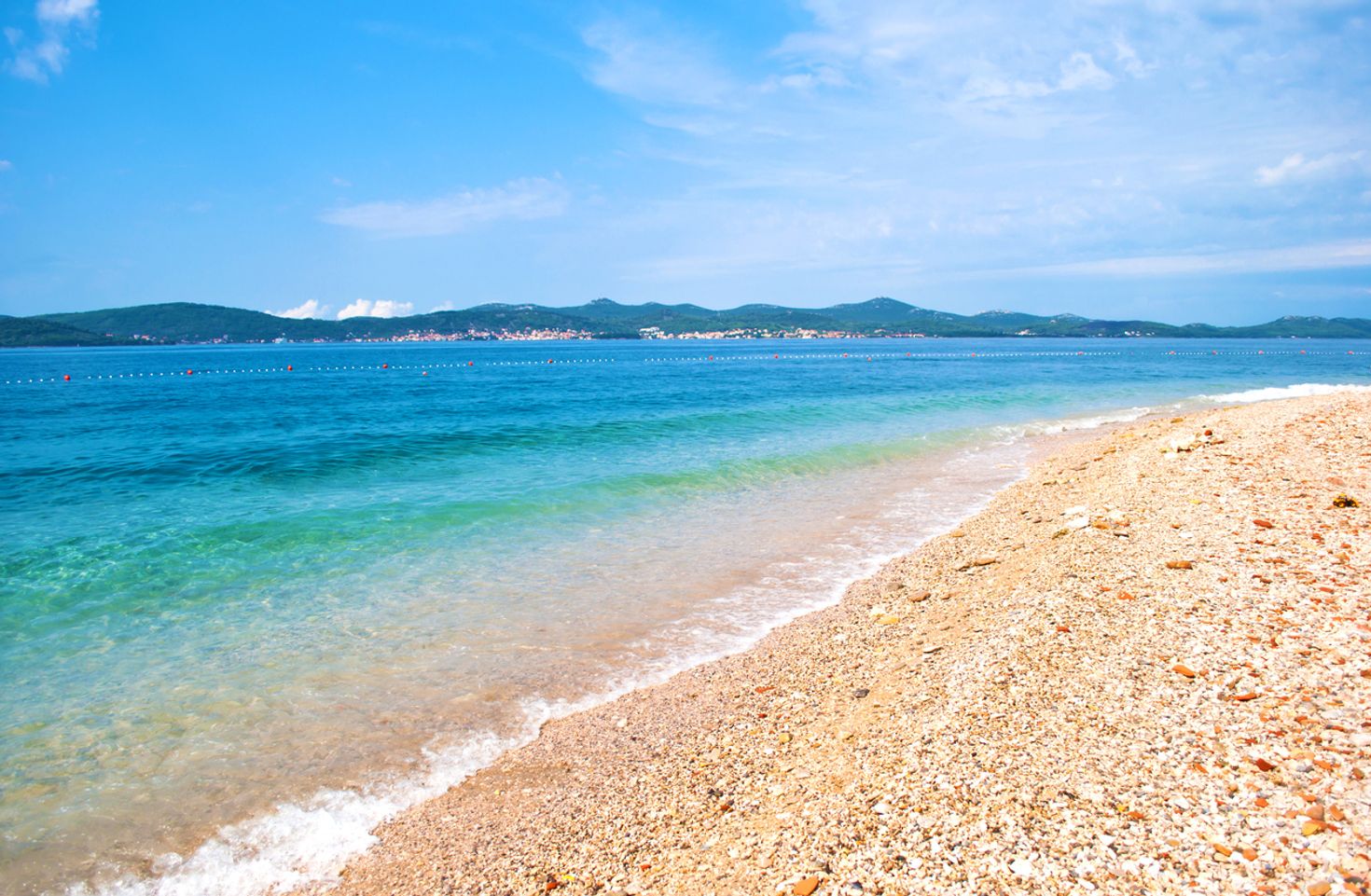The pebbled beach of Zadar in Croatia on a clear day. 