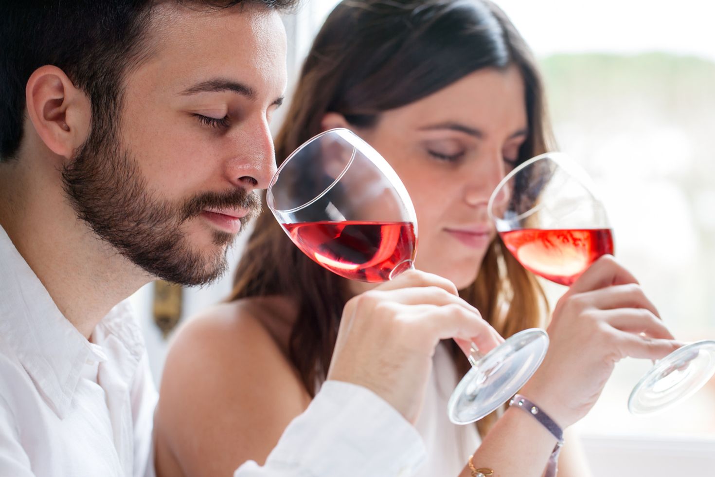 A couple tasting red wine. 
