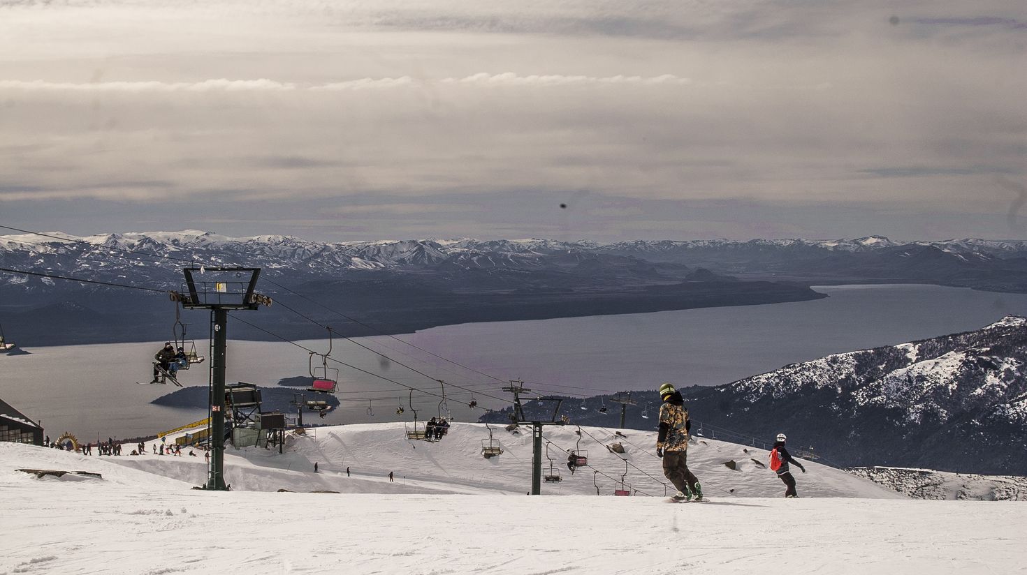 People snowboarding in Cerro Cathedral during dusk, Bariloche.