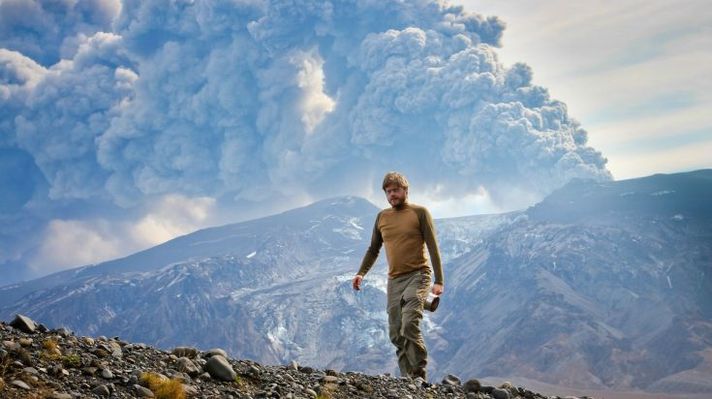A hiker near the Eyjafjallajokull Volcano as it smoulders in the distance.