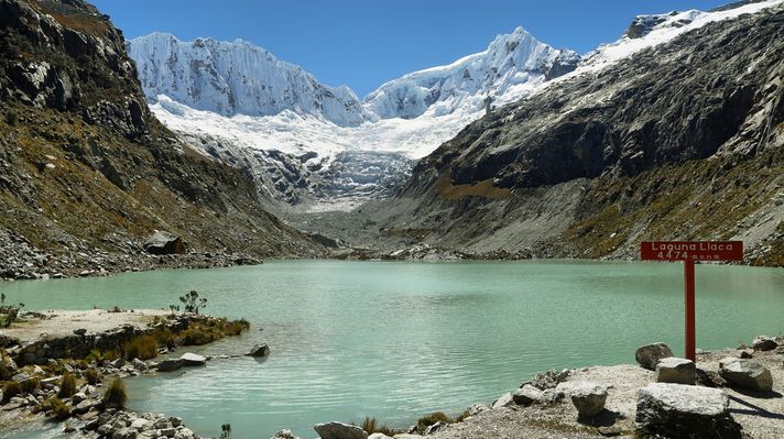 View of a lake with snow-capped mountains in the background in Peru. 