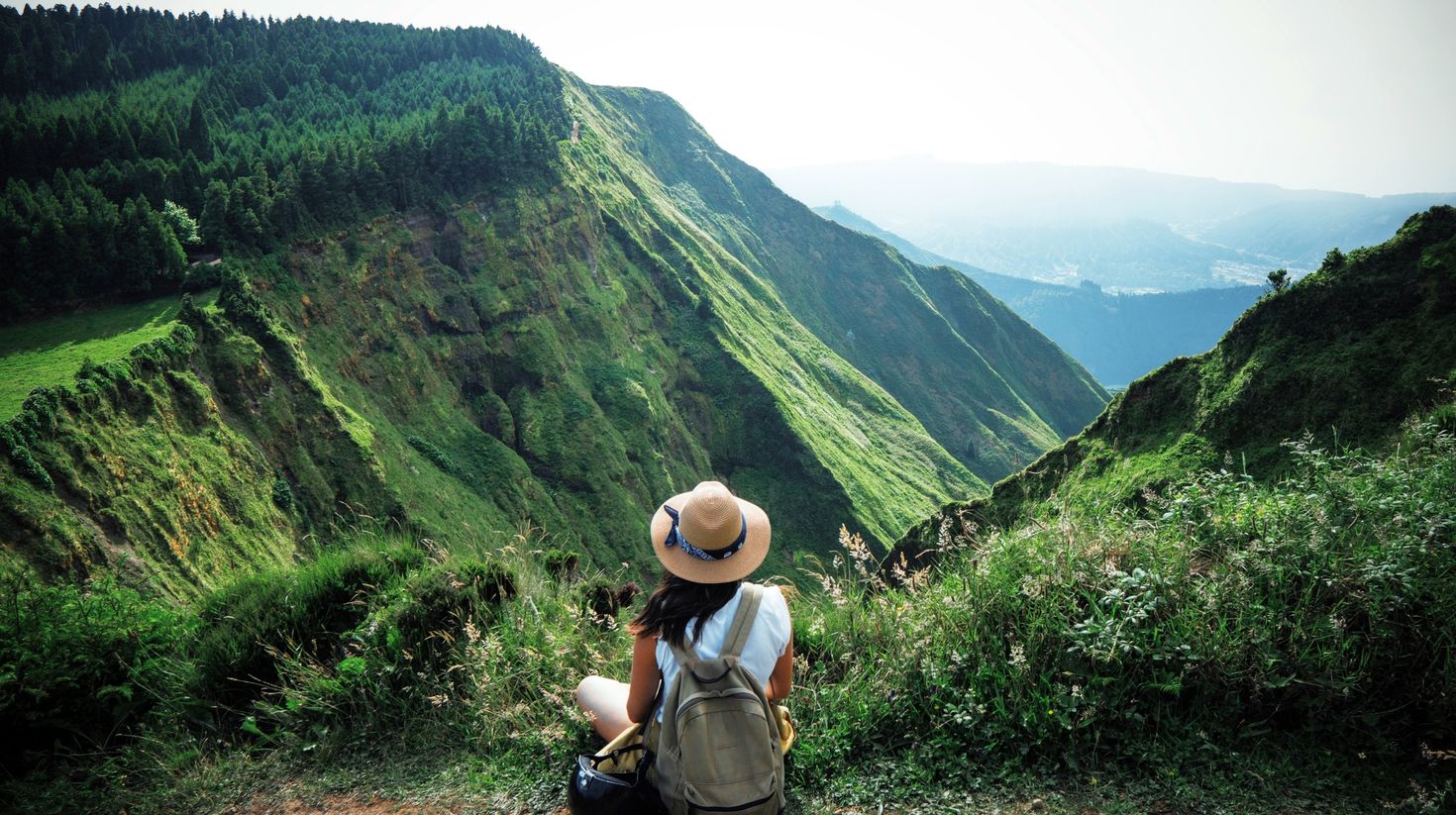 A hiker resting after hiking to the top and admiring the nature in Portugal. 