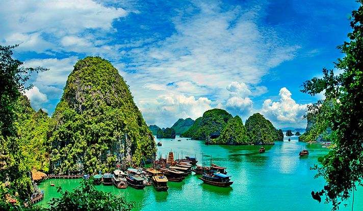 Clear blue water with boats and islands in the distance in Halong Bay Vietnam. 