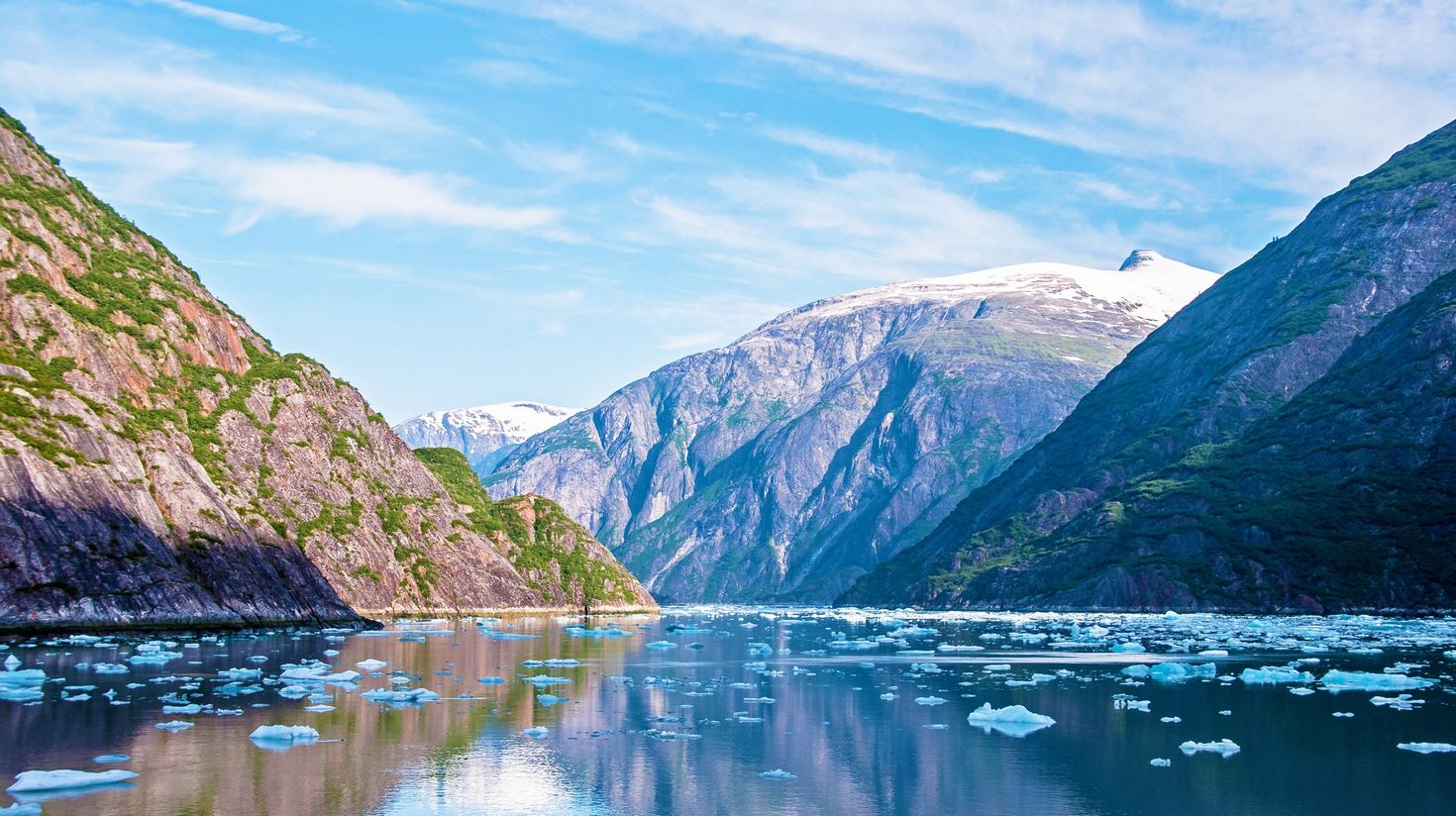 View of rocky ice-capped mountains and floating bits of ice