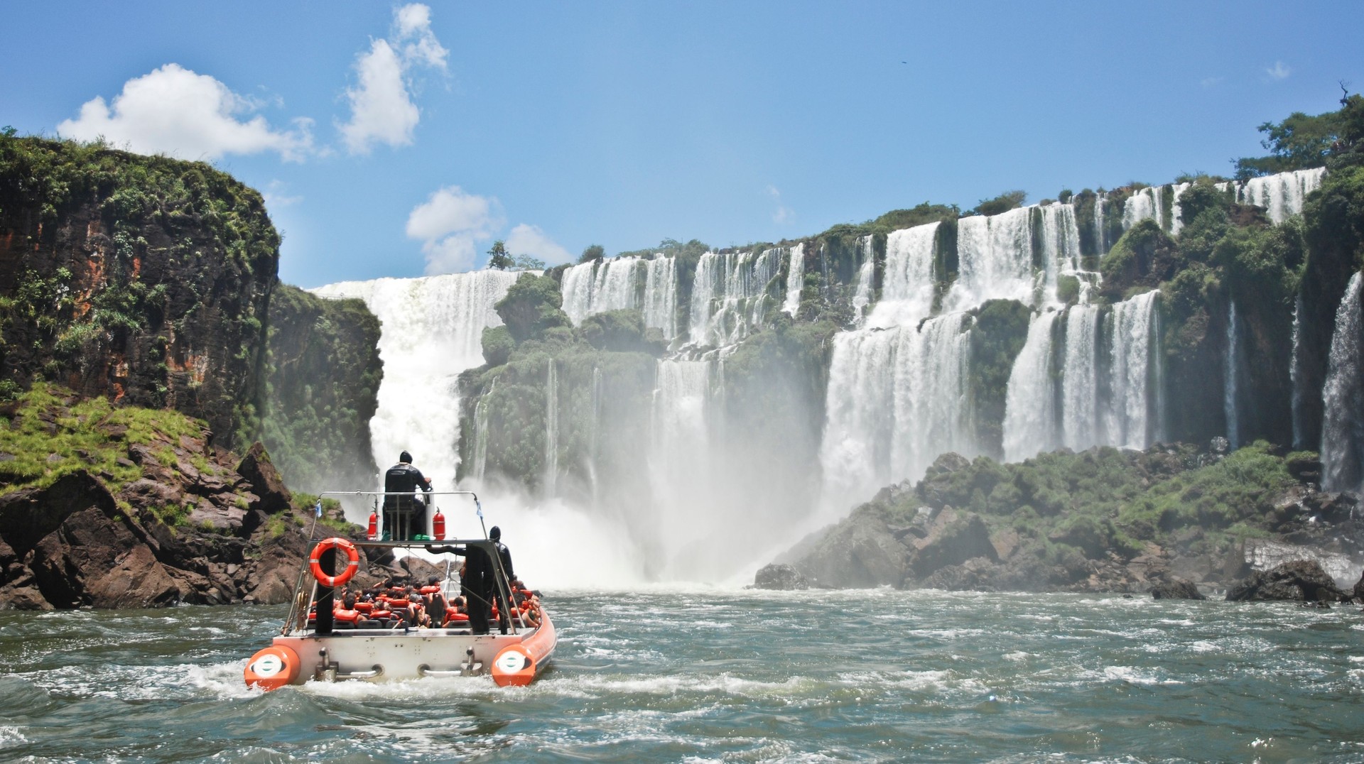 Tourists enjoying boat ride on Iguazu Falls on a clear day during their 12 days in Argentina.