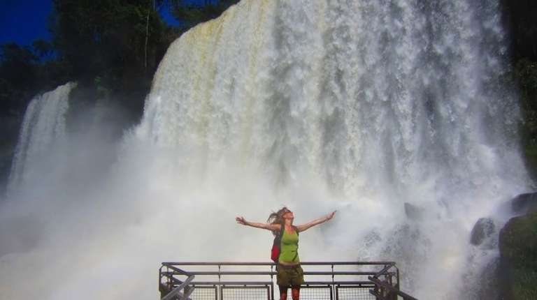 A tourist girl admiring the magnificence of Iguazu Falls during her 3 weeks in Argentina.