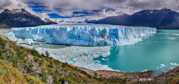 A humongous block of glacier on turquoise lake surrounded