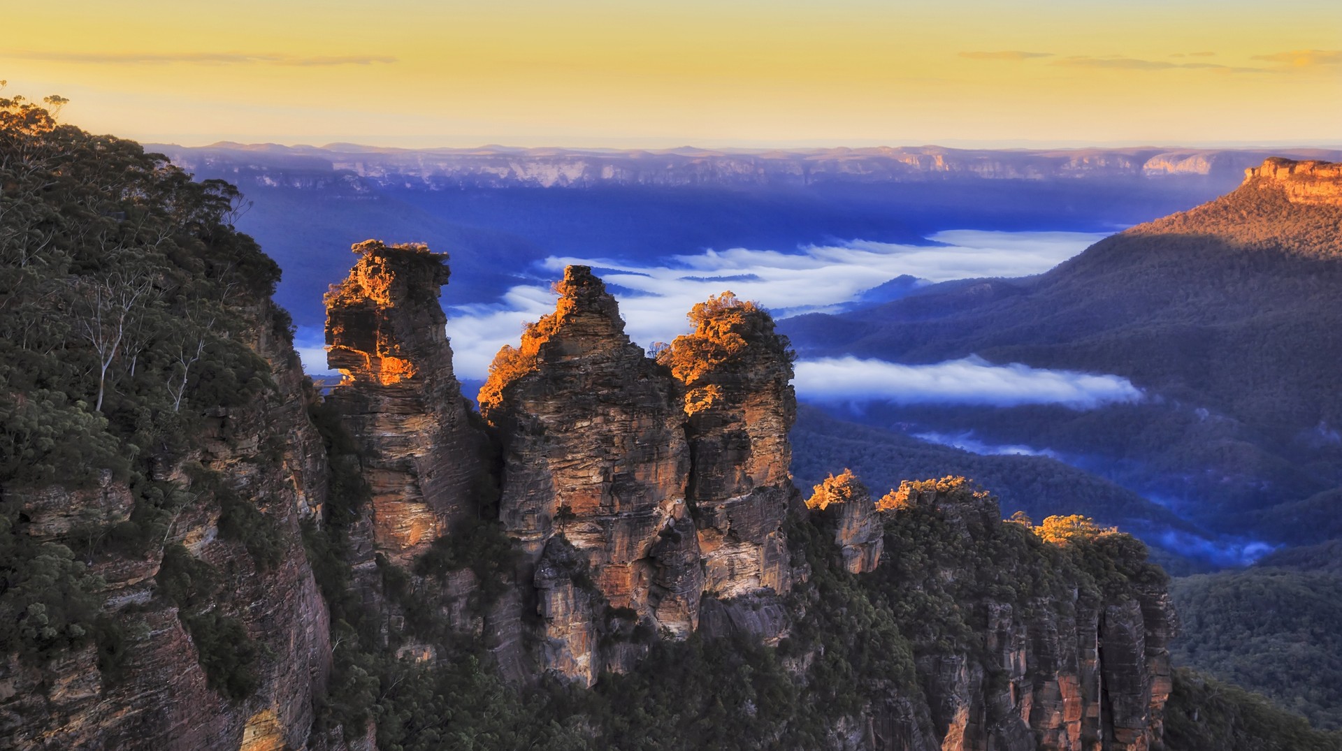 The Three Sisters stand over the Jamison Valley, in the Blue Mountains National Park near Katoomba in Australia during January. Peaks of three sisters of Australia in January.