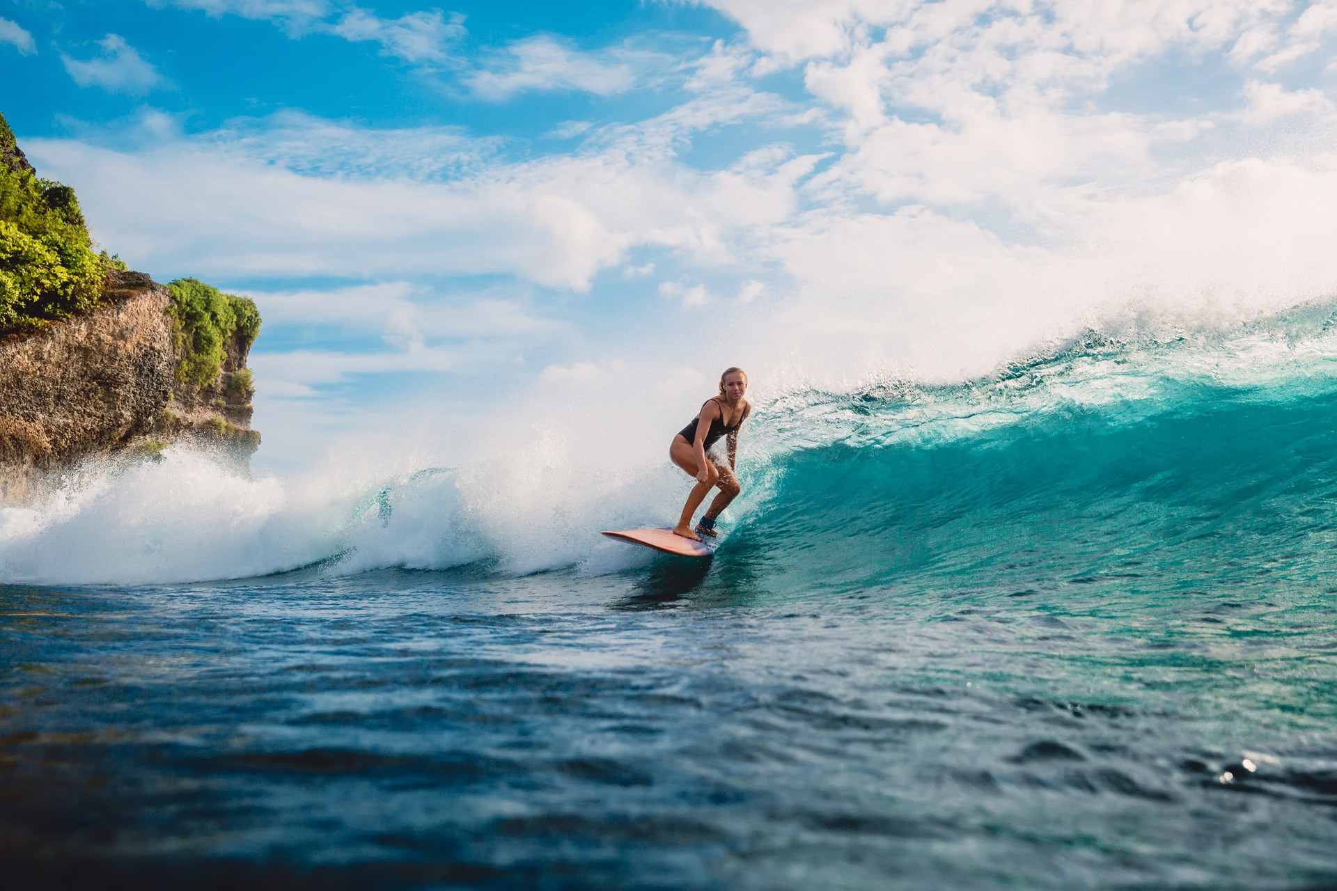 If you love the thrill, you might want to take up surfing when you are in Australia in September. A woman surfing on a board in the beach of Australia in September.