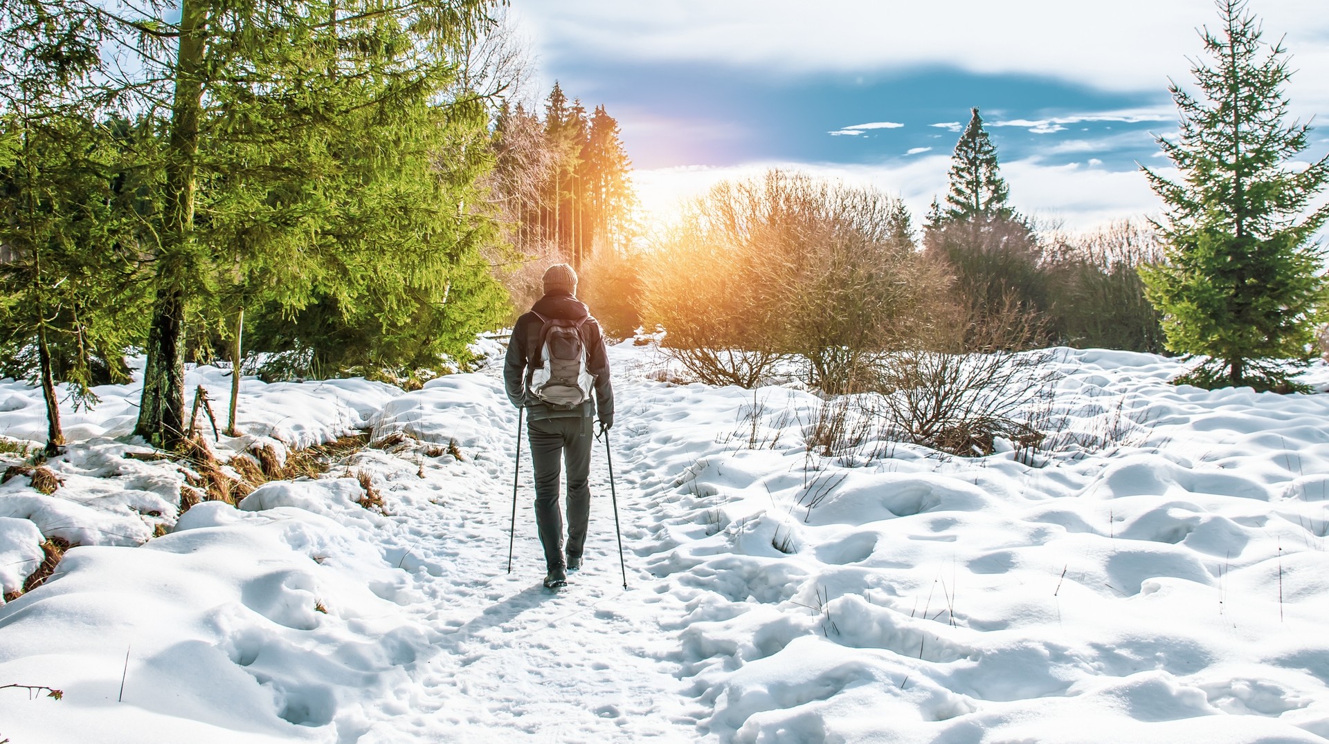 Take to the snowy forest winter hiking trail of Sourbrodt in Ardennes on your visit to Belgium in January. A man hiking a snowy trail in Sourbrodt during his visit to Belgium in January.