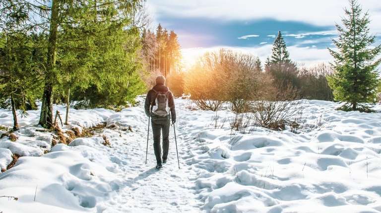 A man hiking a snowy trail in Sourbrodt during his visit to Belgium in January.