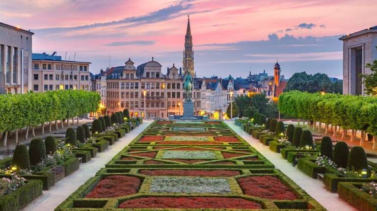 Neatly displayed garden with medieval buildings in the distance in Old Town at sunset in Brussels in Belgium in May.