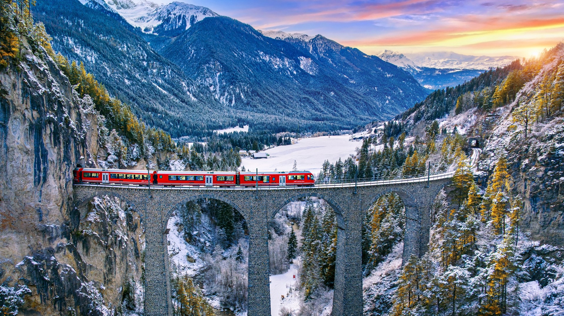 Some of the best places to visit in January are those that embrace winters to its fullest and are blanketed in snow. Train passing through a bridge in Switzerland, one of the best places to visit in January.