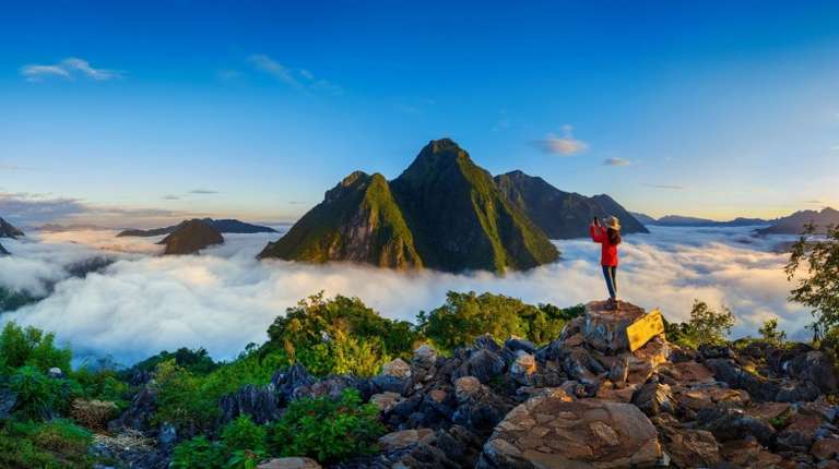 Woman hiking the Pha Dang viewpoint in Laos, one of the best places to visit in November.