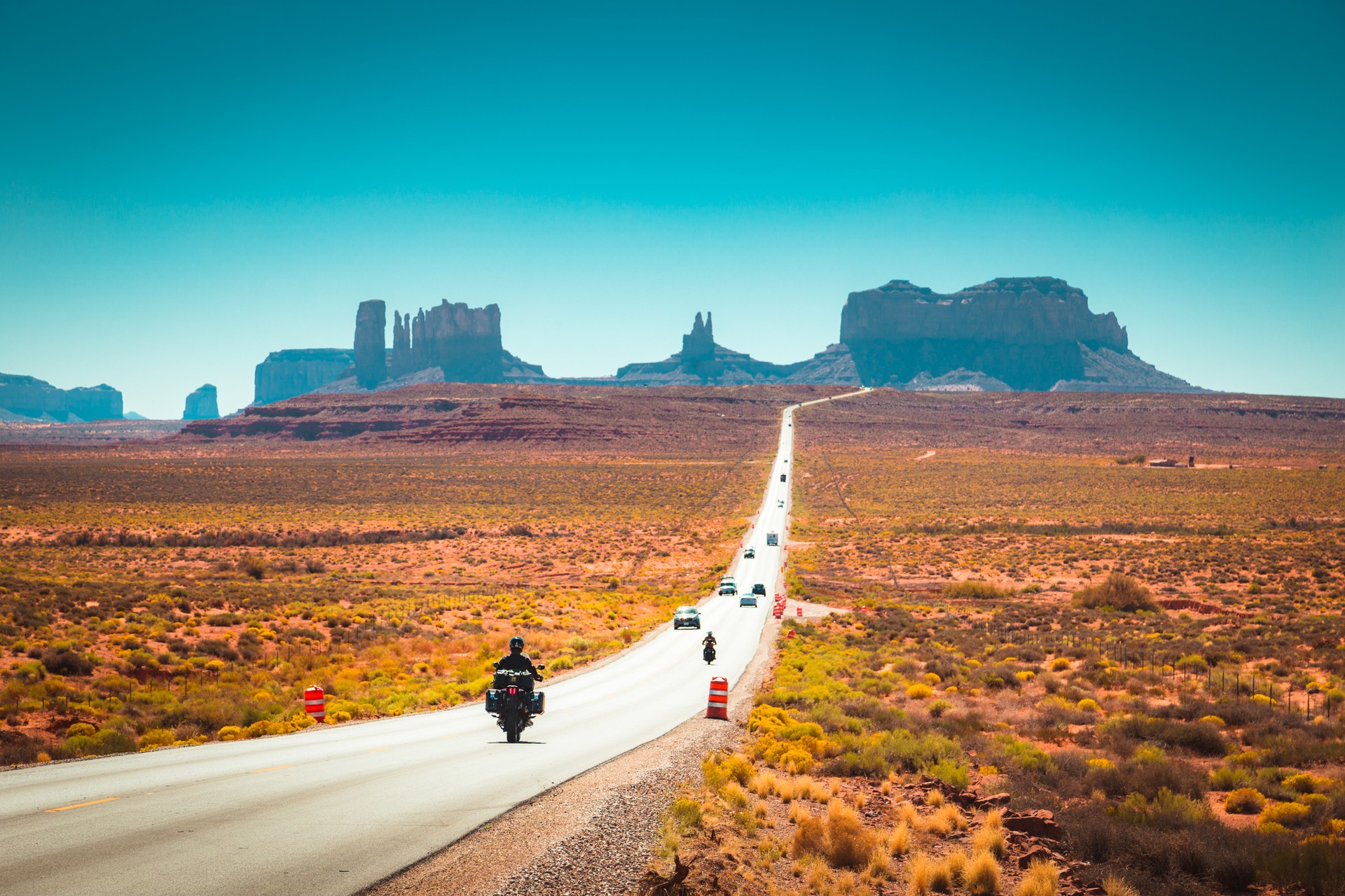 While road-tripping on Route 66, take a detour to the Monument Valley Travelers on the road in motorbikes and cars on the Route 66 highway during the day.