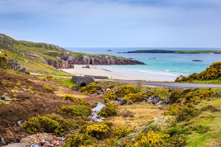 A secluded beach with blue water in Scotland.