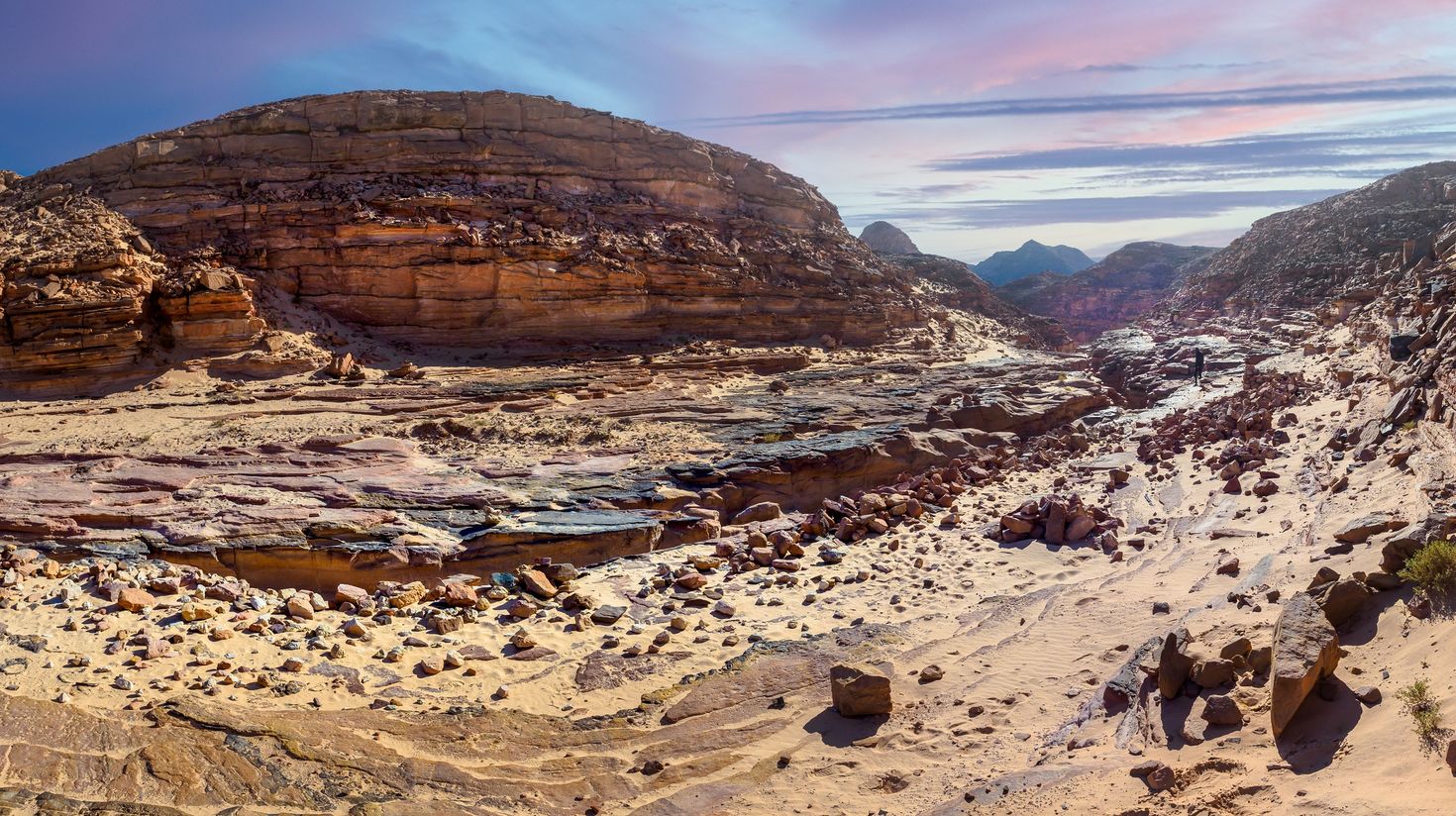 A panoramic view of Colored Canyon with red clouds in Egypt.