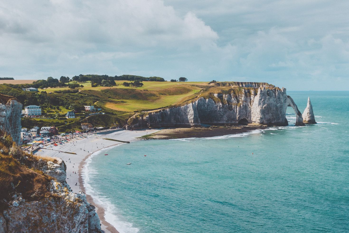 Blue sea next to the green cliffside coastline in France
