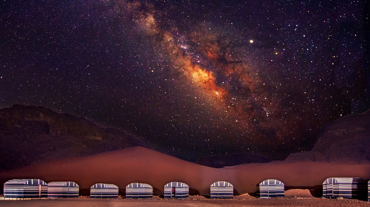 A camp in Jordan's Wadi Rum desert at night with the Milky Way.