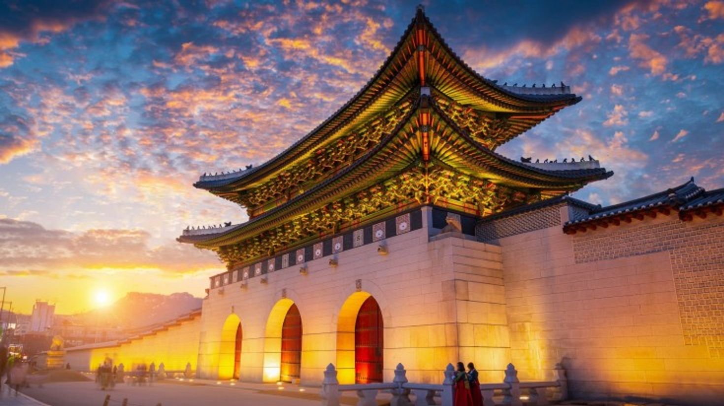 A view of Gyeongbokgung Palace during sunset under a cloudy sky