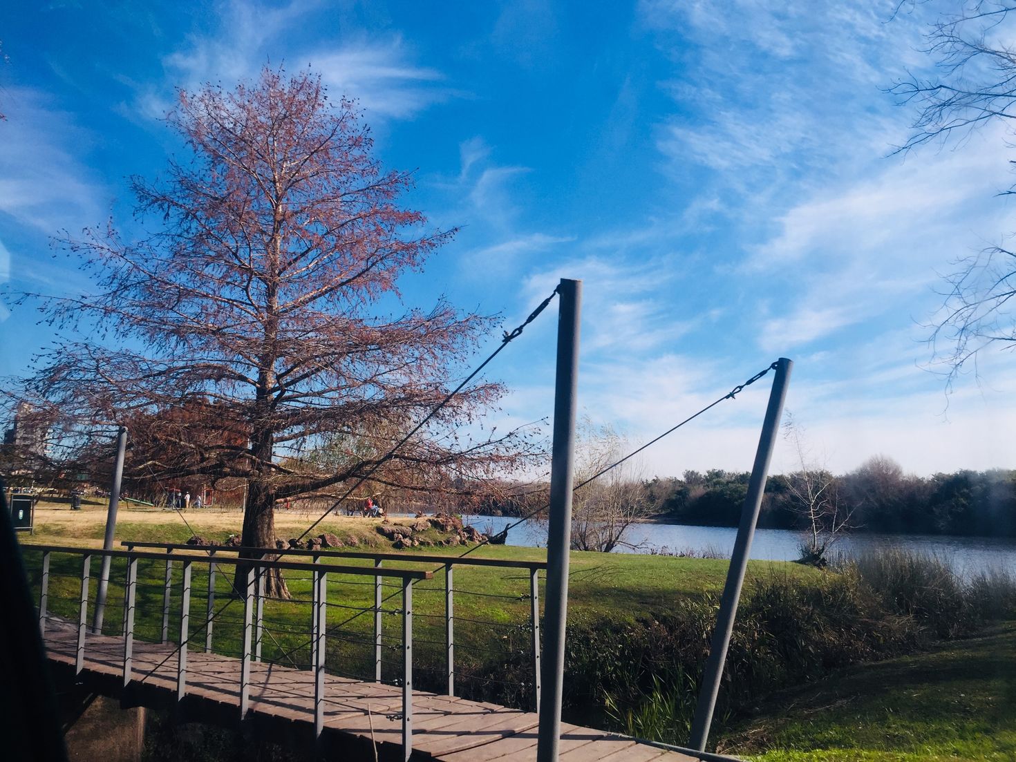 Lake with landscape and suspension bridge during winter.