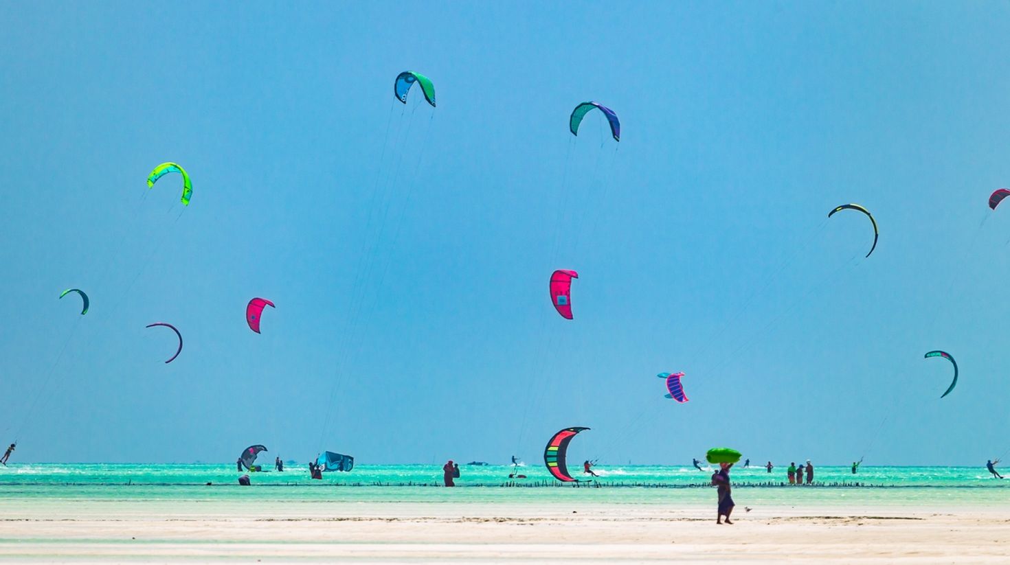Tourists kitesurfing in Paje Beach during an ideal time to visit Zanzibar.