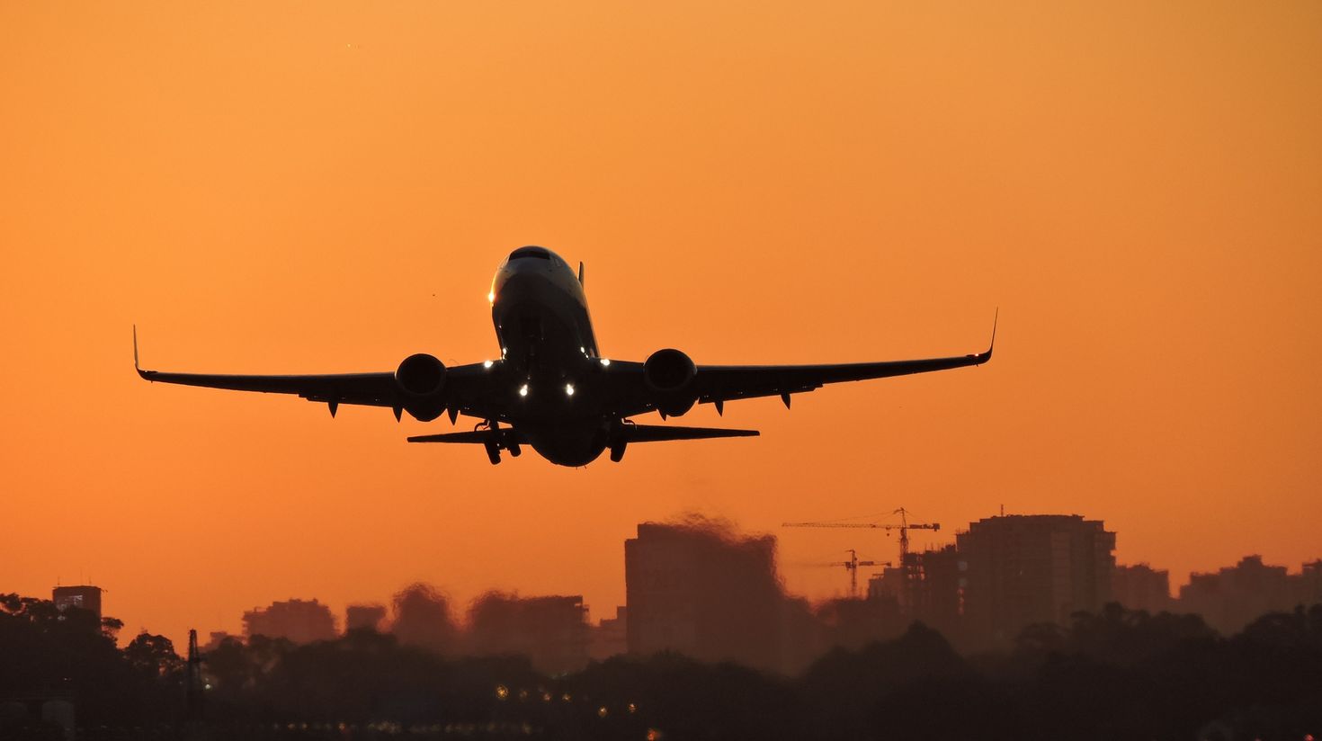 A plane flying in Argentine sky during sunset.