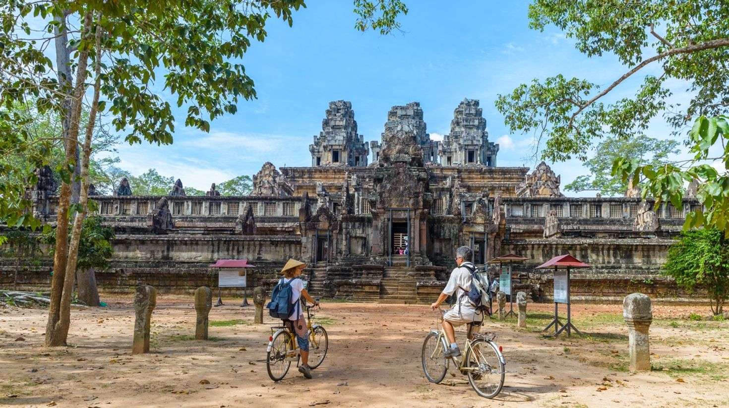 People cycling around Angkor temple in Cambodia