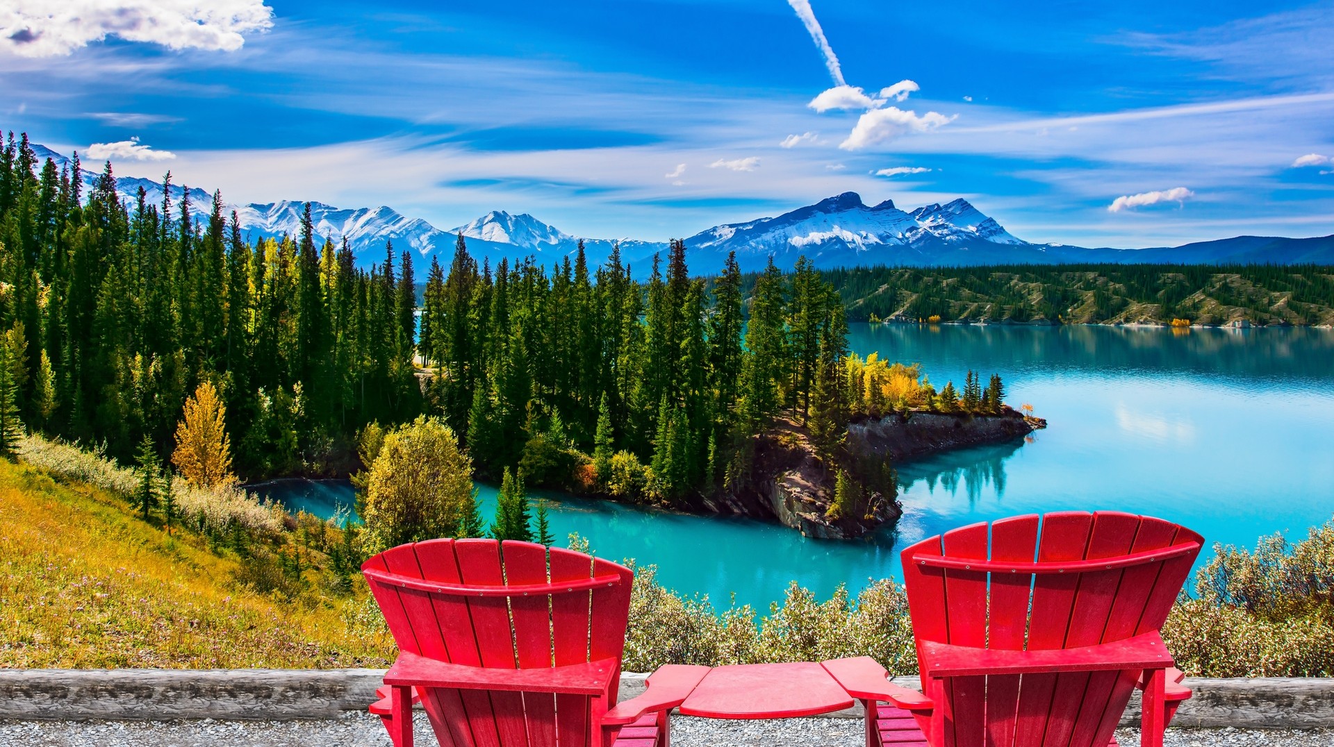 From pleasant weather and minimal crowds to wine festivals and luscious rainforest trails, Canada in September is a must-visit. Two red loungers by the Abraham lake overlooking the trees and the mountains in Canada in September.