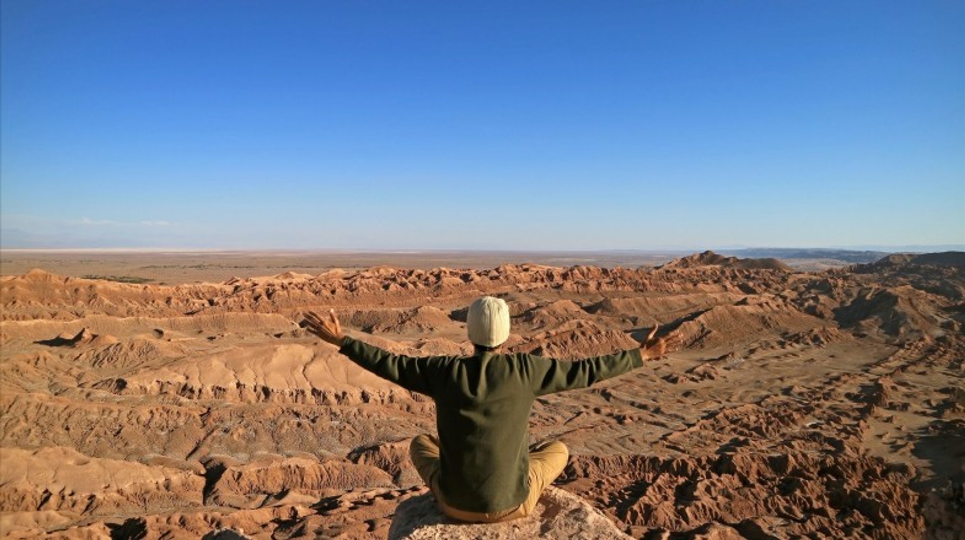 A man with open arms in San Pedro Atacama on a clear day during his 2 weeks in Chile.